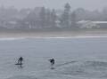 Surfing in the rain at Bellambi on May 6, 2024. Picture by Sylvia Liber