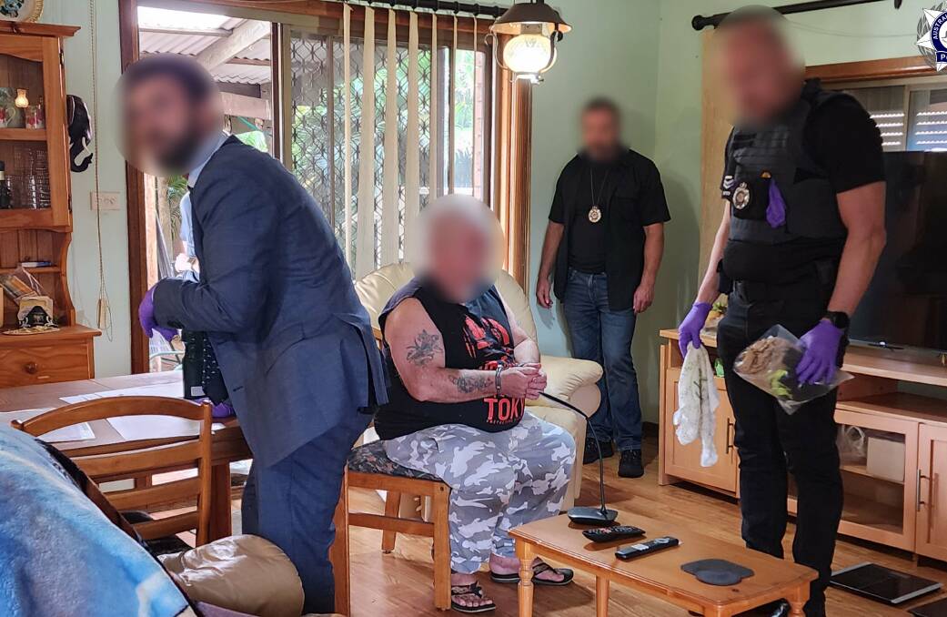 Graham Cook being arrested at his Lake Heights home on February 15. Picture by AFP