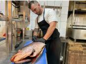 Sam Smith prepares a fish for diners at Nowra's Ponte Bar and Dining. Picture by Glenn Ellard.