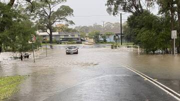 A car was stuck in floodwater covering Berry St, Nowra, early today (Thursday, June 6).