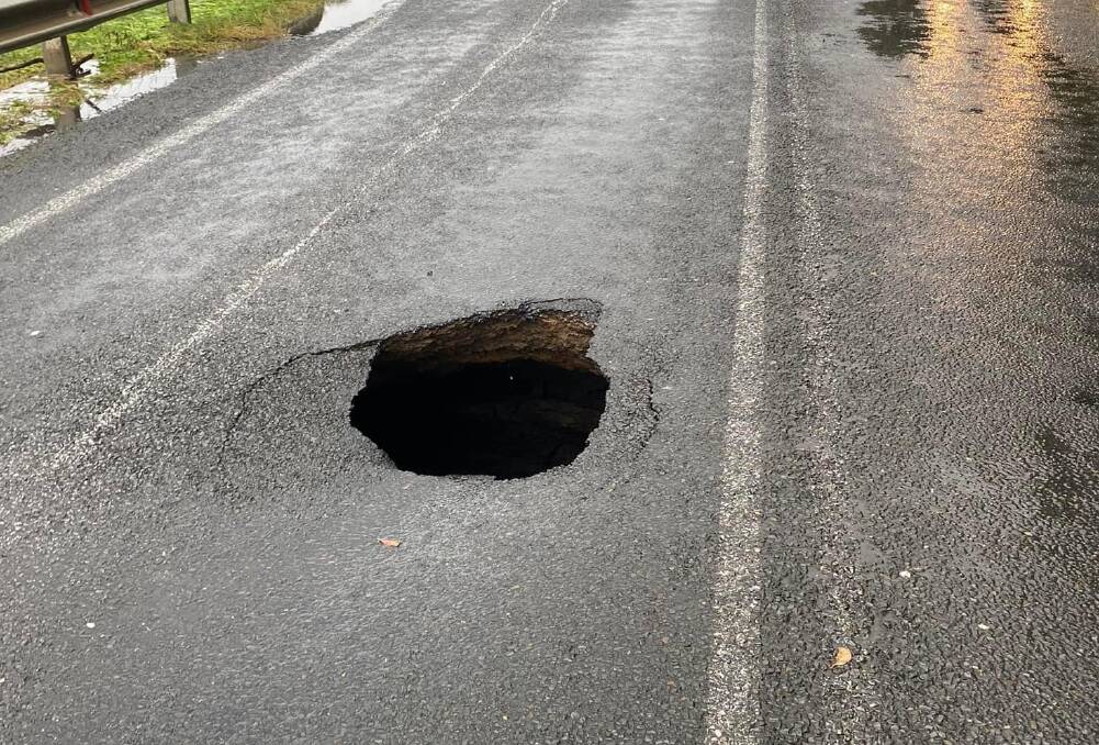 Flooding across The Wool Road at Old Erowal Bay last week left a sink hole in the middle of the road. Picture supplied.