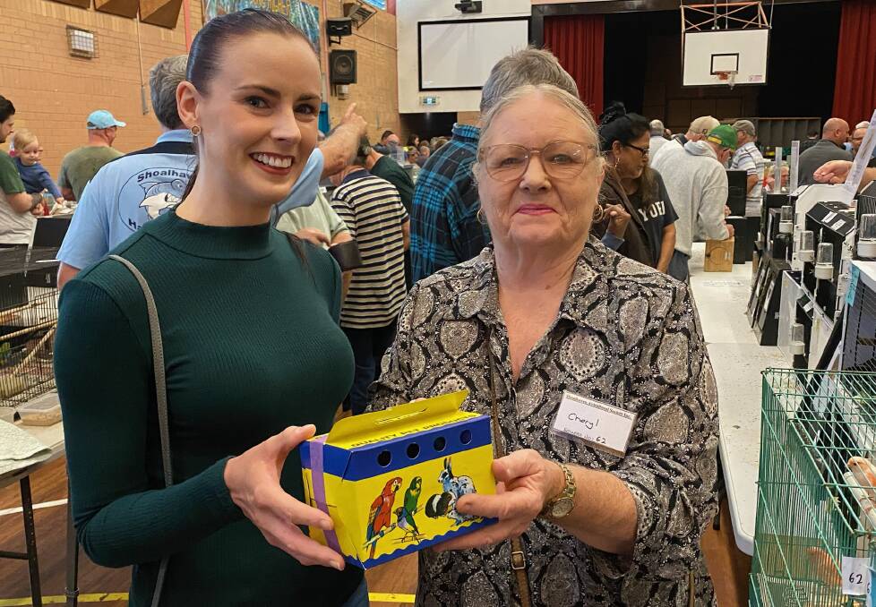 Lake Sayer of Culburra Beach buys a canary in a carry box from Ulladulla's Cheryl Webster during the annual bird sale. Picture by Glenn Ellard.