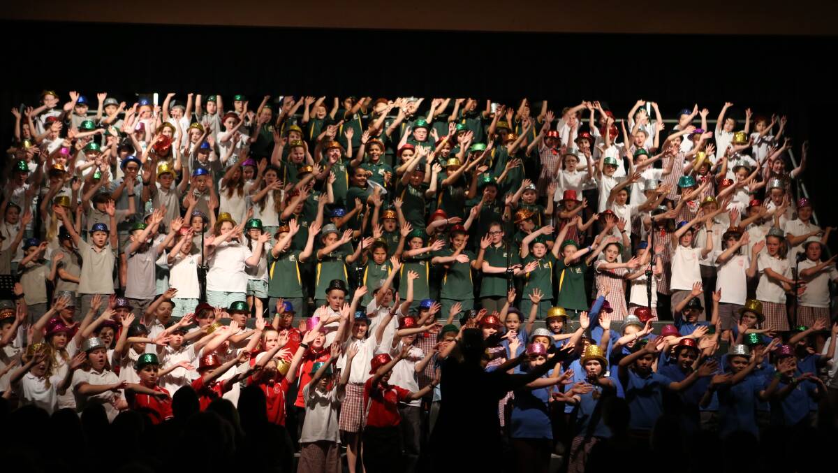 EN MASSE: Students from Thursday night’s performance get into the groove during one of the mass choir performances.
