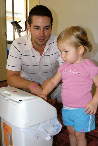 BIN IT: With Shoalhaven Mayor Paul Green talking about re-educating people about waste, Jeremy Granger of North Nowra helps teach daughter Fallon about what things need to go in the bin.